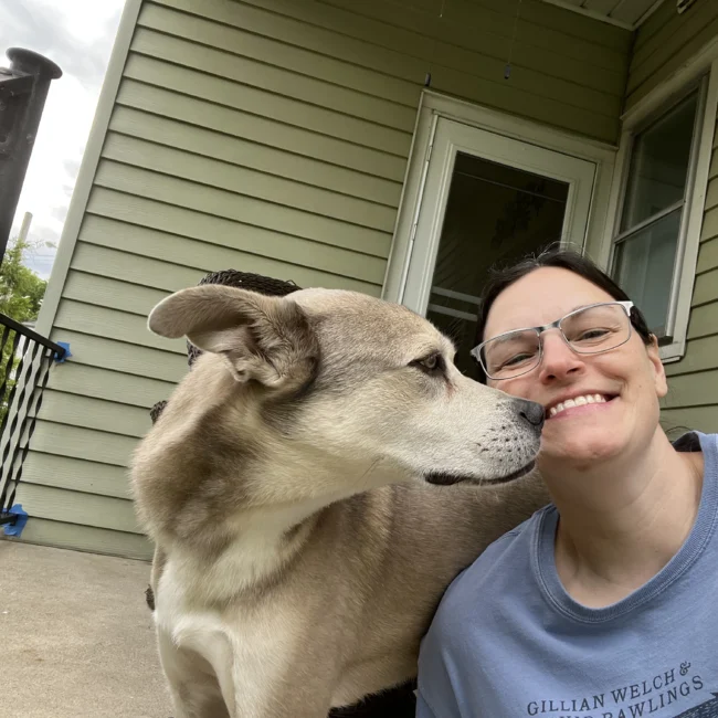 Amanda sitting next to her dog on her porch.